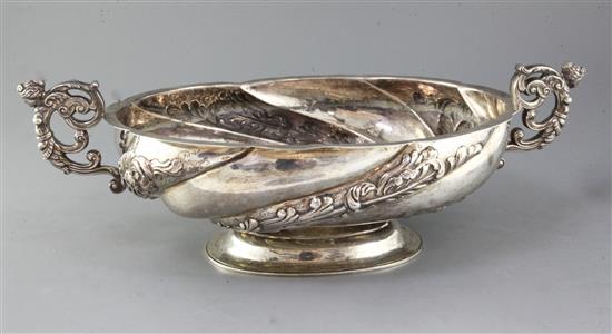 An oval embossed silver pedestal bowl with twin scrolled caryatid handles, London 1899, maker Elkington & Co Ltd, 58.2oz